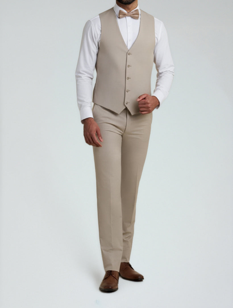 A man showcases effortless style in the Allure Men's Tan Tailored Fit Vest and matching trousers, paired with a white shirt, bow tie, and brown dress shoes, standing against a plain light background.