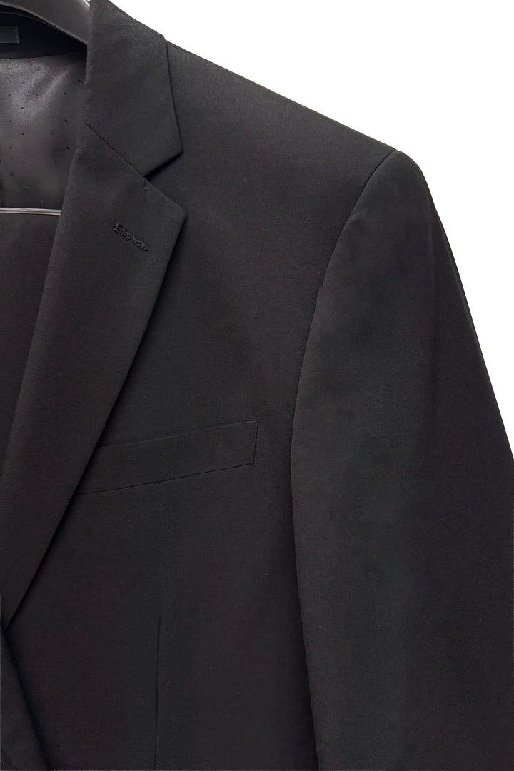 Close-up of the Karako Men Mens Black Suit jacket on a hanger, highlighting the lapel, chest pocket, and upper sleeve—ideal as a classic men’s wedding suit or prom suit.