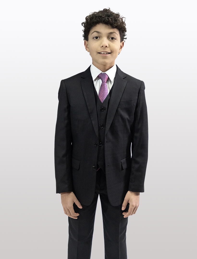 A young person with curly hair stands against a plain background wearing a Karako Boys' Black Classic Fit Vested Suit, featuring a notch lapel, paired with a white shirt and purple tie.