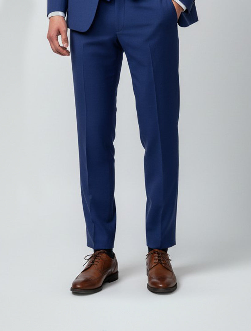 A person models the lower half dressed in Karako Separate Blue Men's Slim-Fit Suit Separates Pants with brown dress shoes against a plain light background, highlighting sleek, professional office attire.