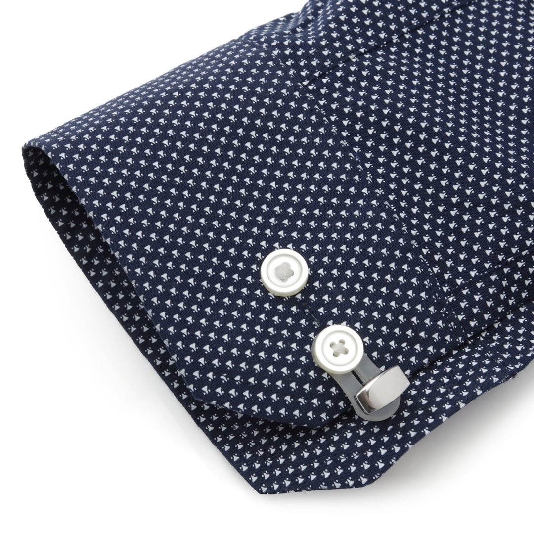 Cufflink Adapters with silicone tabs attached to the button of a navy blue patterned dress shirt cuff.