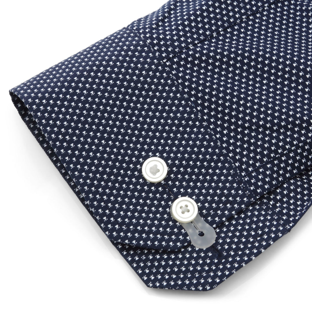 Clear silicone Cufflink Adapters attached to the buttons of a navy blue patterned dress shirt sleeve.