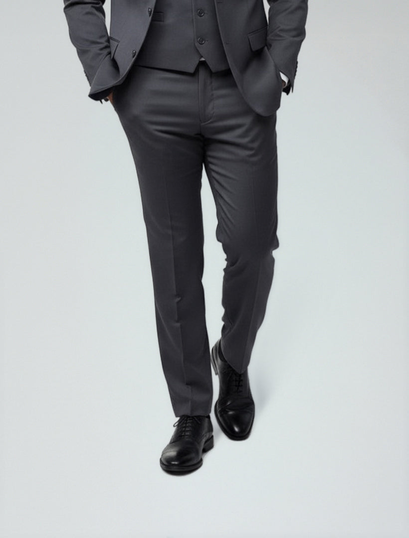 A person wearing Karako Separate Charcoal Grey Men's Slim-Fit Suit Separates Pants and black dress shoes stands with hands in pockets against a light gray background, their face not shown.