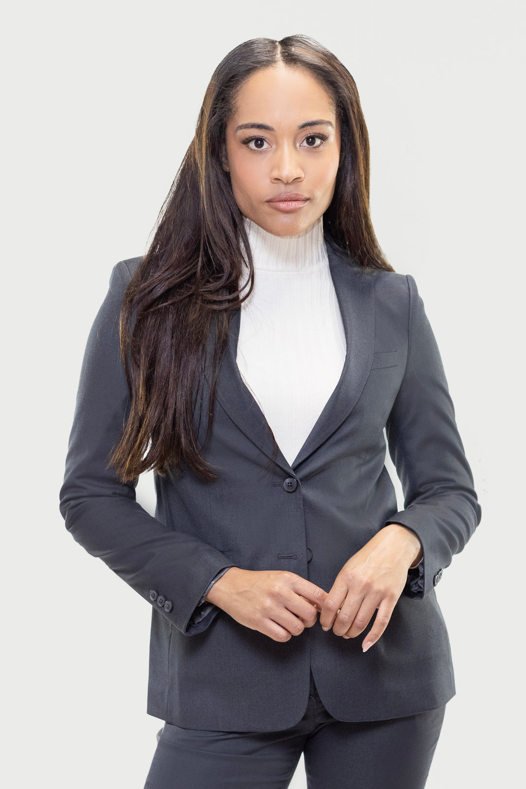 A woman with long brown hair stands confidently in a Couture 1910 Women&