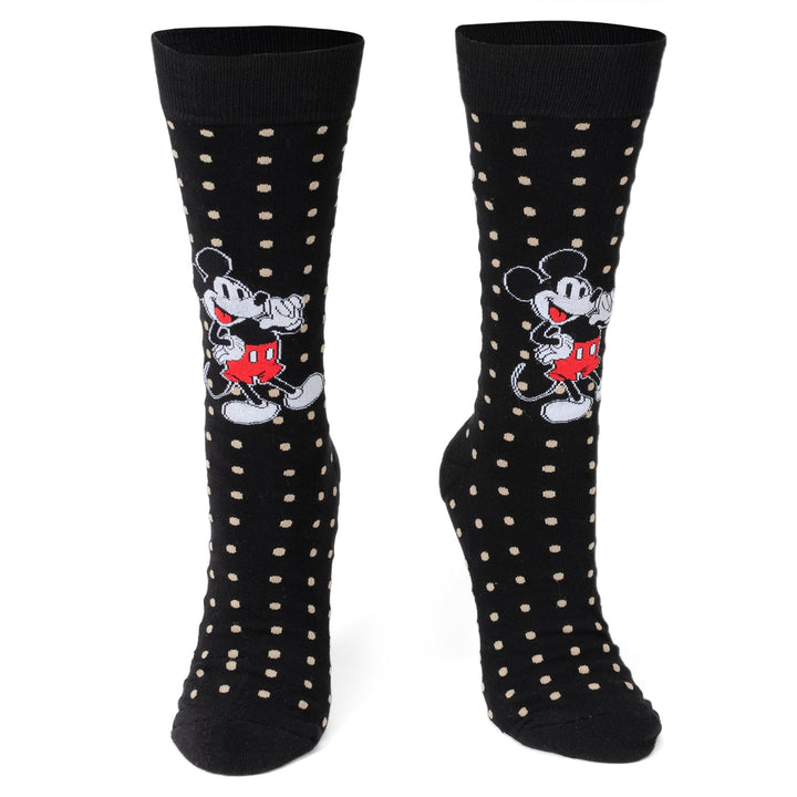 A pair of Disney Mickey Mouse Dot Socks and Blue Lapel Pin Gift Set black socks with tan polka dots and a repeating Mickey Mouse pattern.