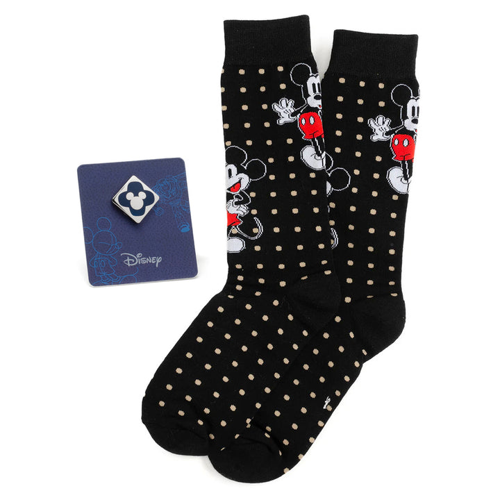 Disney Mickey Mouse Dot Socks and Blue Lapel Pin Gift Set featuring black crew socks with a tan polka dot pattern and Mickey Mouse icons, displayed with a blue lapel pin on a card.