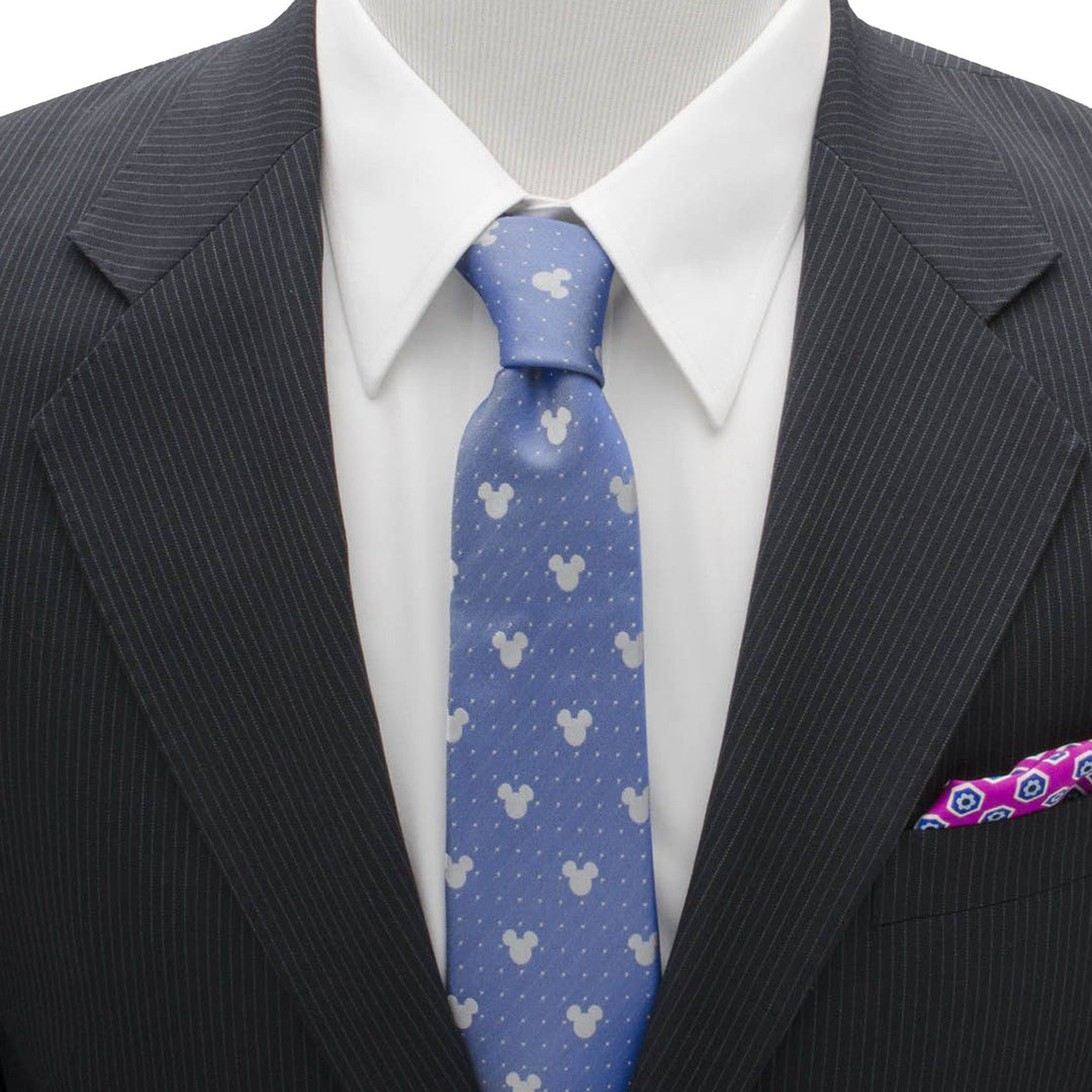 A blue Disney Mickey Mouse Blue Pin Dot Men’s Tie with white silhouettes and small dots, worn with a white shirt, pinstriped suit jacket, and patterned pocket square.