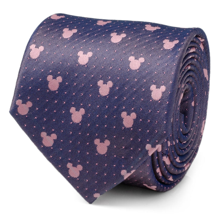A rolled-up Disney Mickey Mouse Purple and Pink Dot Silhouette Tie in dark blue silk with a repeating print of light pink Mickey Mouse silhouettes and small dots.