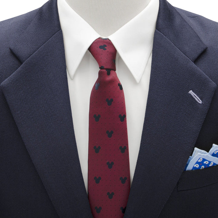 Disney Mickey Mouse Red Pin Dot Men’s Tie in red with a repeating black icon pattern, worn with a white dress shirt and navy blazer.