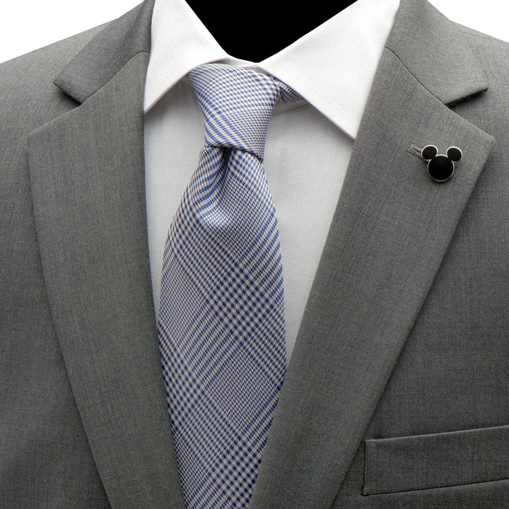 A Disney Mickey and Friends Checkered Black Gift Set displayed as a gray suit jacket worn over a white dress shirt with a blue plaid tie, a Mickey Mouse lapel pin, and checkered socks.