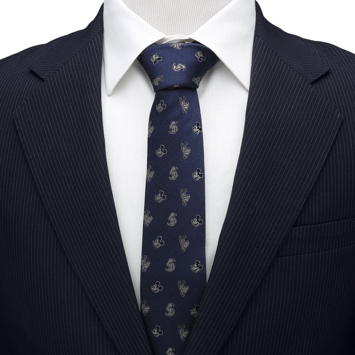 Disney Mickey and Friends Blue Men’s Tie in dark blue 100% silk with a repeating gold Mickey Mouse icon pattern, worn with a white collared shirt and pinstriped suit jacket.