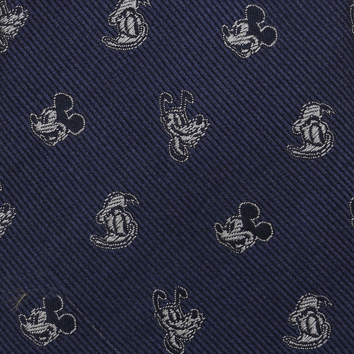 A dark blue 100% silk Disney Mickey and Friends Blue Men’s Tie featuring a repeating pattern of Mickey Mouse and Pluto silhouettes in silver thread.