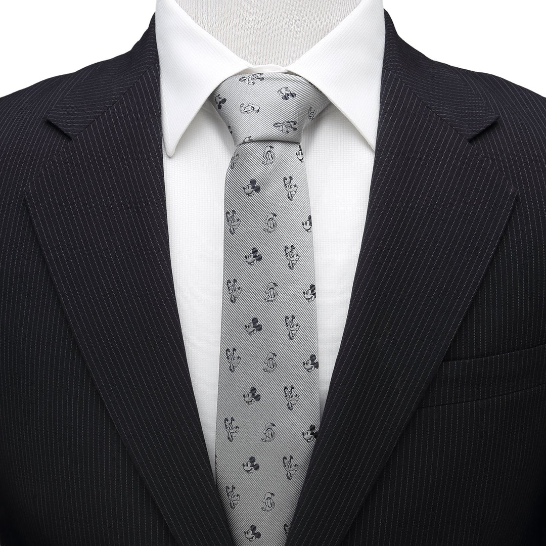 Disney Mickey and Friends Gray Men’s Tie in 100% silk with a repeating character pattern, worn with a white dress shirt and dark pinstriped suit jacket.