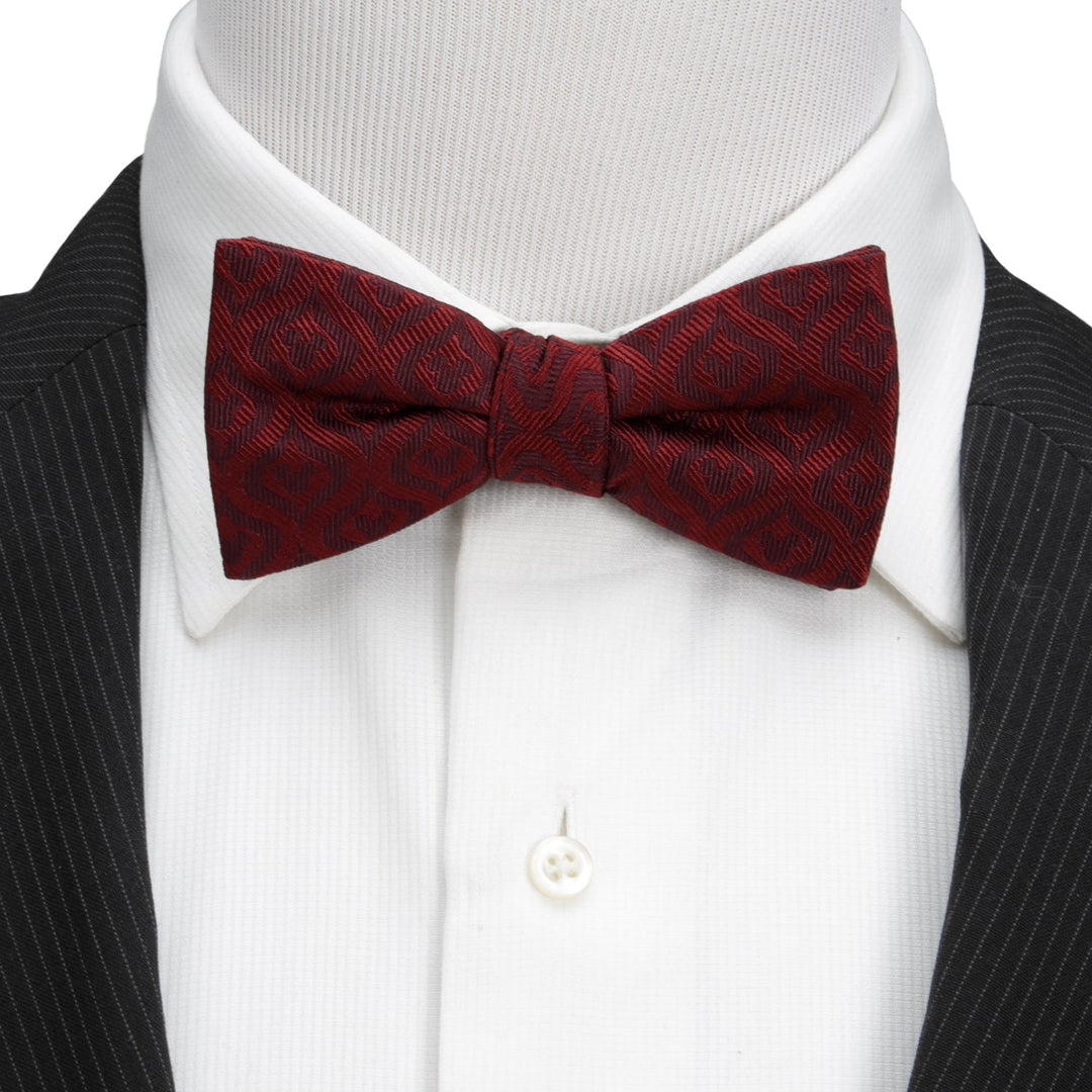 Disney Mickey Mouse Holiday Maroon Bow Tie with a repeating silhouette pattern, worn on a white collared shirt and black pinstriped suit jacket.