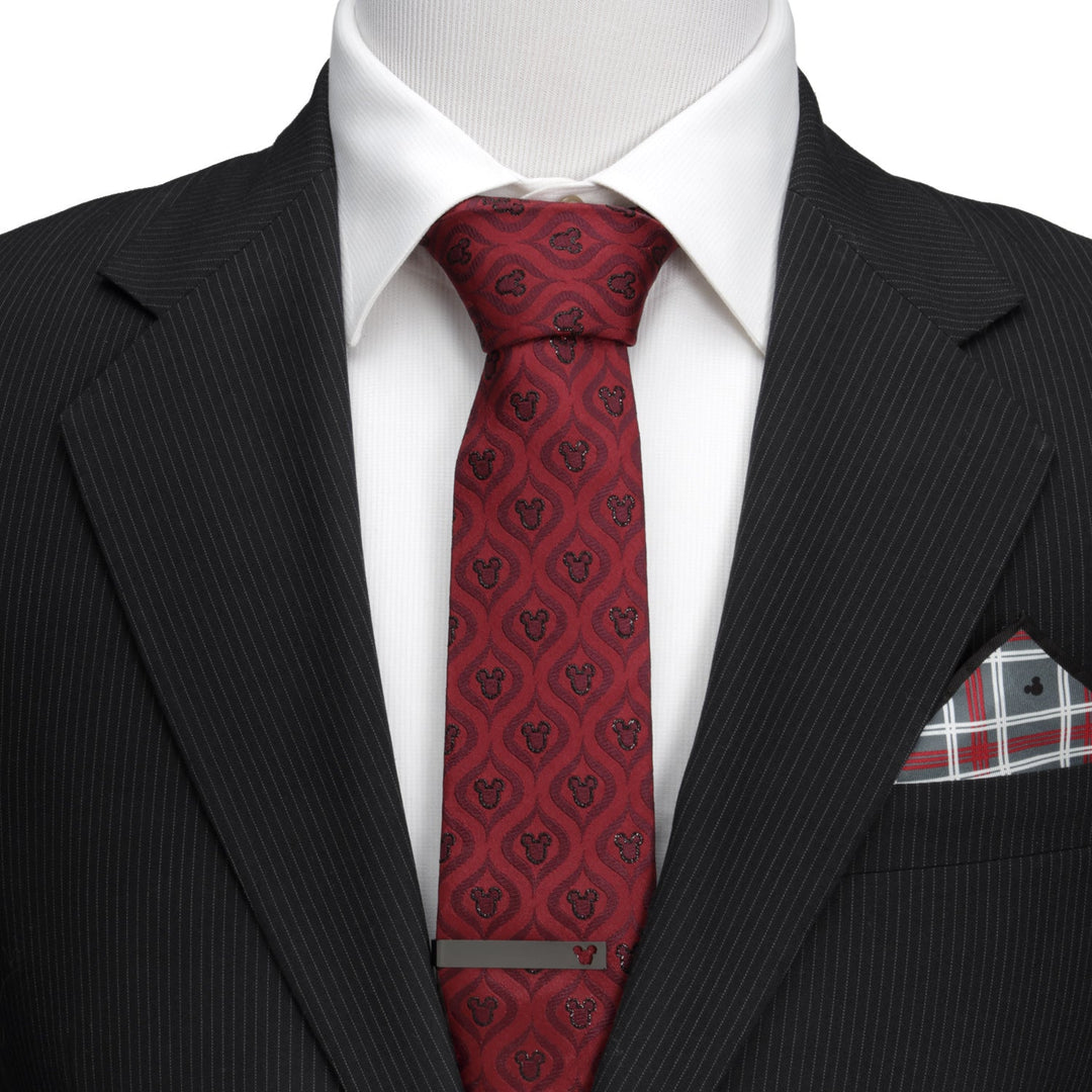 A man’s white dress shirt and black pinstripe suit jacket worn with a Disney Mickey Mouse Holiday Metallic Black Silk Men’s Tie featuring a repeating silhouette pattern and a metal tie bar.