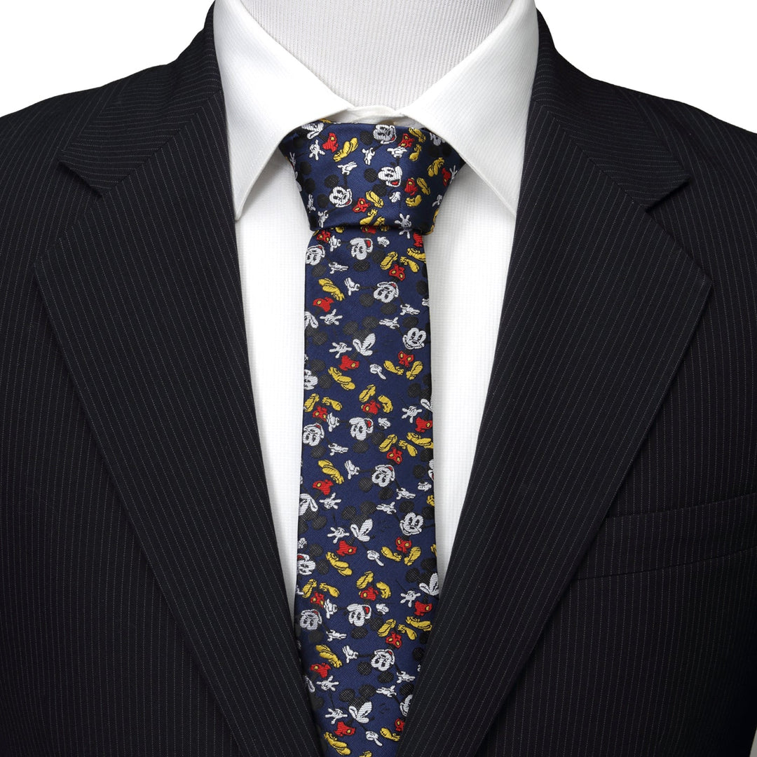 Disney Mickey Mouse Action Navy Men’s Tie featuring a navy blue pattern of Mickey Mouse heads and gloved hands, worn with a white shirt and black suit jacket.
