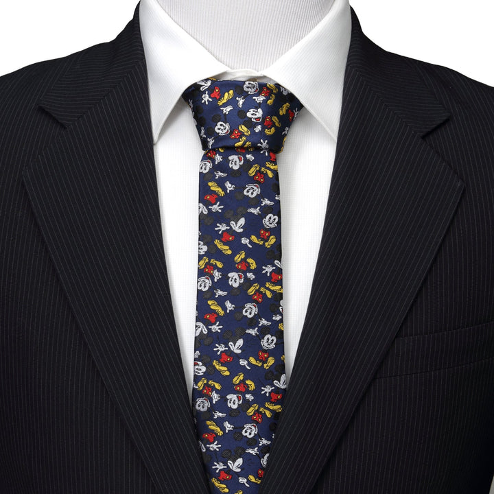 Disney Mickey Mouse Action Navy Men’s Tie featuring a navy blue pattern of Mickey Mouse heads and gloved hands, worn with a white shirt and black suit jacket.