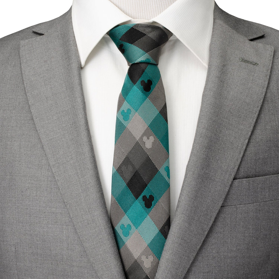 Disney Mickey Mouse Silhouette Teal Plaid Men’s Tie in teal, grey, and black plaid, worn with a white shirt and grey suit jacket.