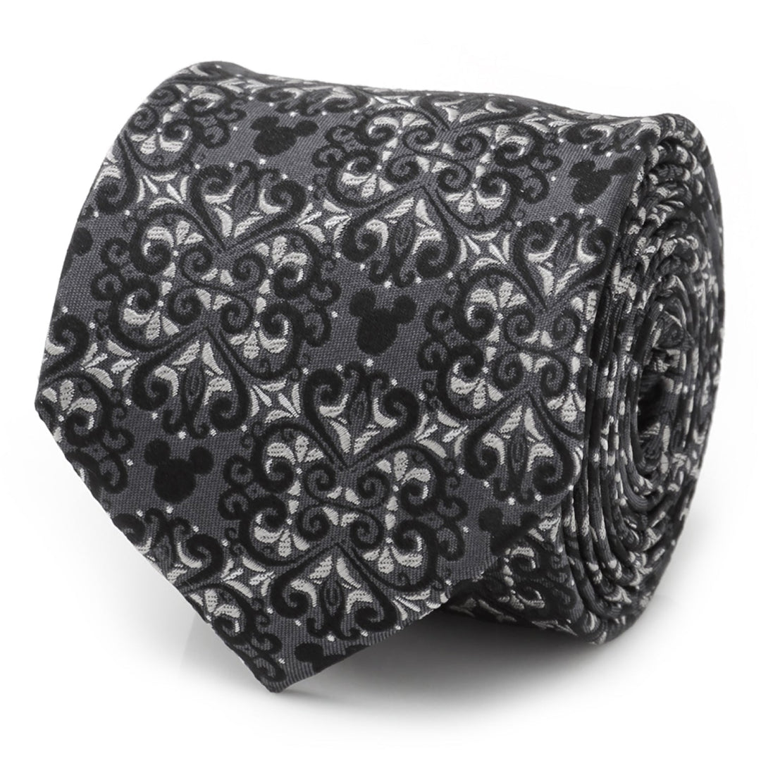 A dark gray Disney Mickey Mouse Damask Tile Men’s Tie rolled into a coil, featuring a black and gray damask pattern integrated with iconic character silhouettes.