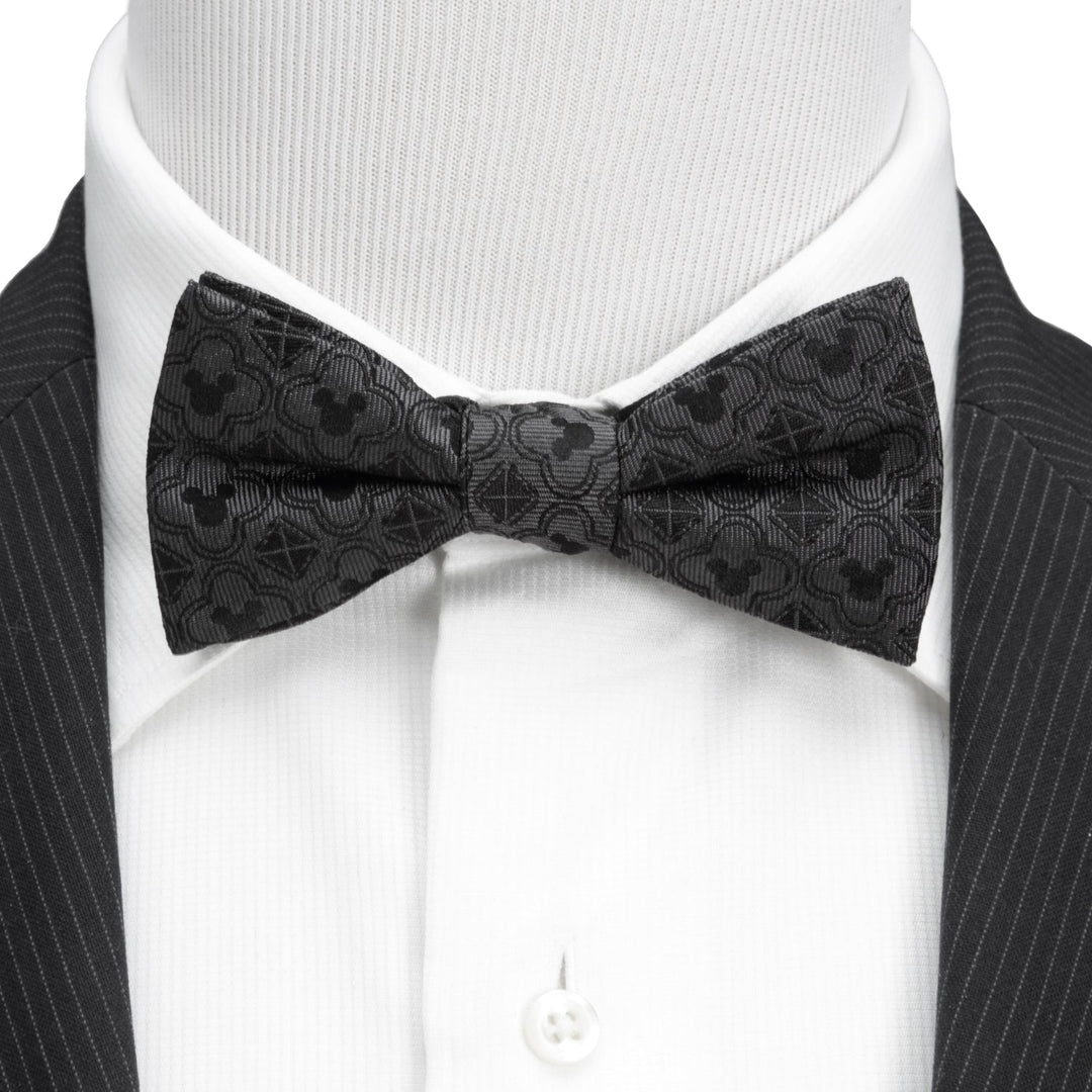 Disney Mickey Mouse Pattern Black Bow Tie in silk with a tonal icon pattern, worn with a white dress shirt and dark pinstriped suit jacket.