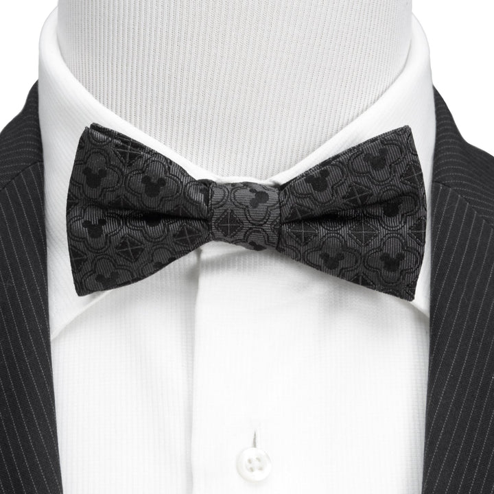 Disney Mickey Mouse Pattern Black Bow Tie in silk with a tonal icon pattern, worn with a white dress shirt and dark pinstriped suit jacket.
