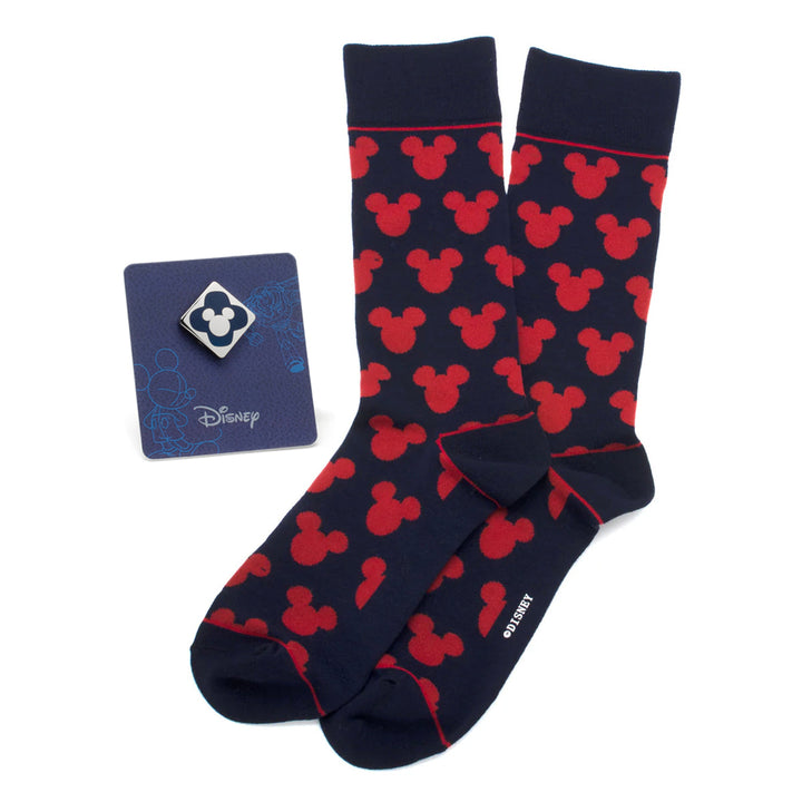 Disney Mickey Mouse Silhouette Blue Sock and Mickey Blue Lapel Pin Gift Set featuring navy blue socks with a repeating red Mickey Mouse silhouette pattern next to a square metal Mickey lapel pin.