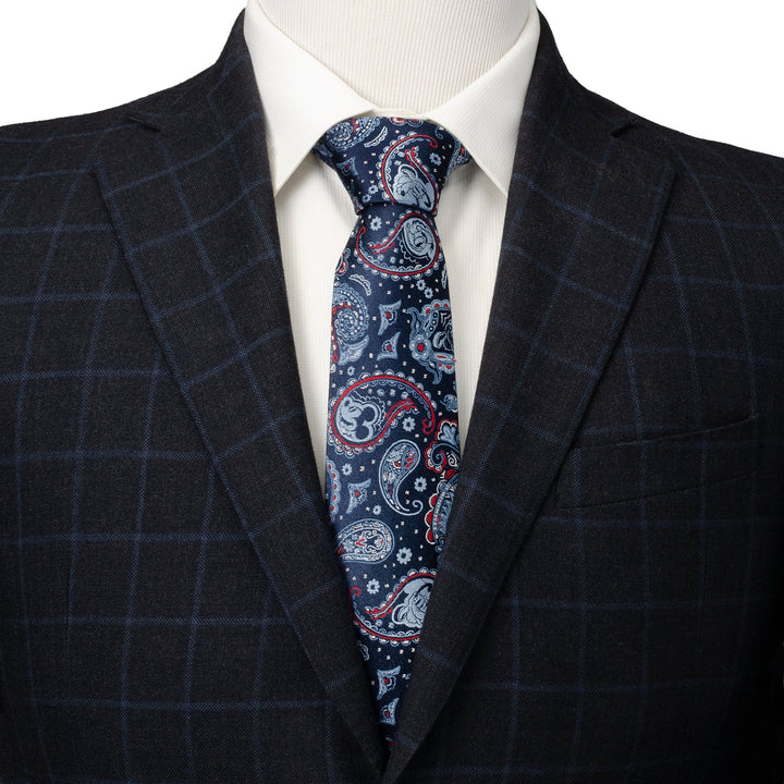 Disney Mickey and Friends Paisley Blue Multi Men’s Tie in dark blue with a white and red paisley pattern featuring hidden Mickey silhouettes, worn with a white shirt and a dark plaid blazer.