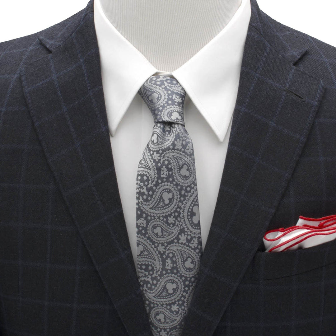Disney Mickey Mouse Gray Paisley Mens Tie in gray silk with subtle silhouettes, worn with a white shirt, a dark plaid blazer, and a red-trimmed white pocket square.