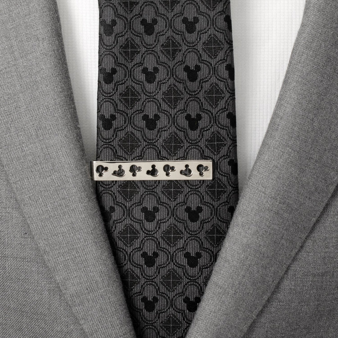 Disney Mickey Mouse Silhouette Cutout Silver Tie Bar pinned to a dark grey patterned tie and light grey suit jacket.