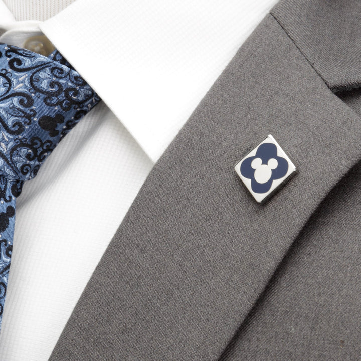 A Disney Mickey Mouse Silhouette Chevron Sock and Mickey Blue Lapel Pin Gift Set featuring a square blue Mickey icon pin on a grey suit lapel, next to a white shirt and patterned blue tie.