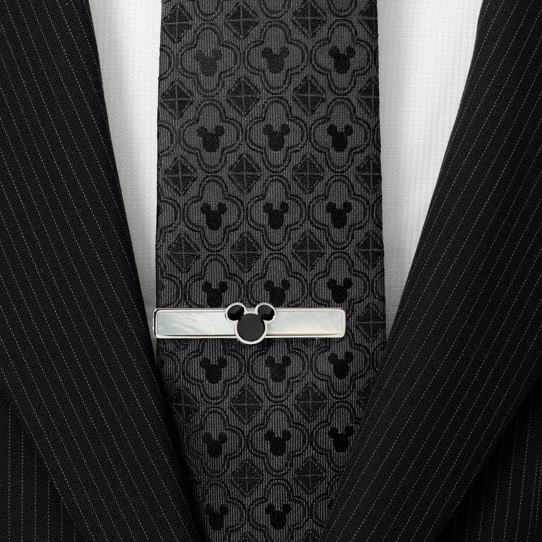 Disney Mickey Mouse Mother of Pearl Tie Clip, featuring a rectangular sterling silver design with mother-of-pearl inlay and a black Mickey Mouse silhouette, pinned to a dark patterned tie.