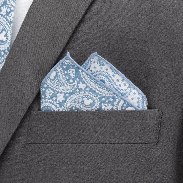 A teal and white Disney Mickey Mouse Paisley Teal Pocket Square with hidden Mickey Mouse silhouettes, tucked into the breast pocket of a grey suit jacket.