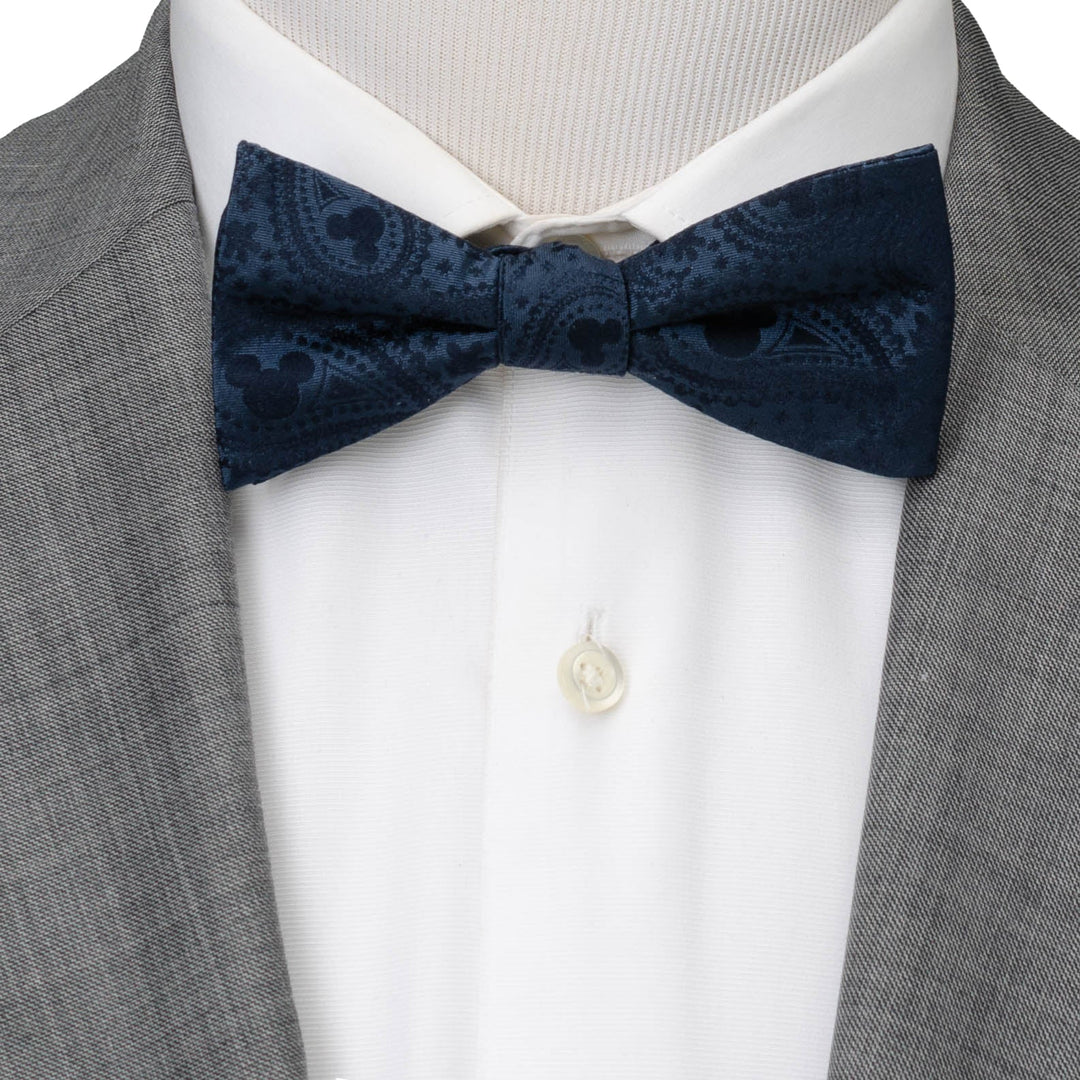 Disney Mickey Mouse Navy Paisley Bow Tie in navy blue worn with a white dress shirt and grey suit jacket.