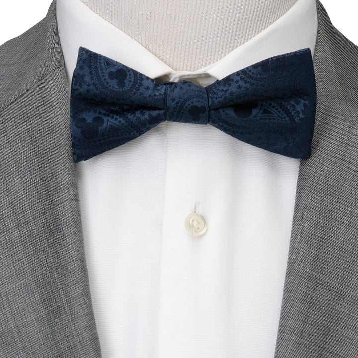 Disney Mickey Mouse Navy Paisley Bow Tie in navy blue worn with a white dress shirt and grey suit jacket.