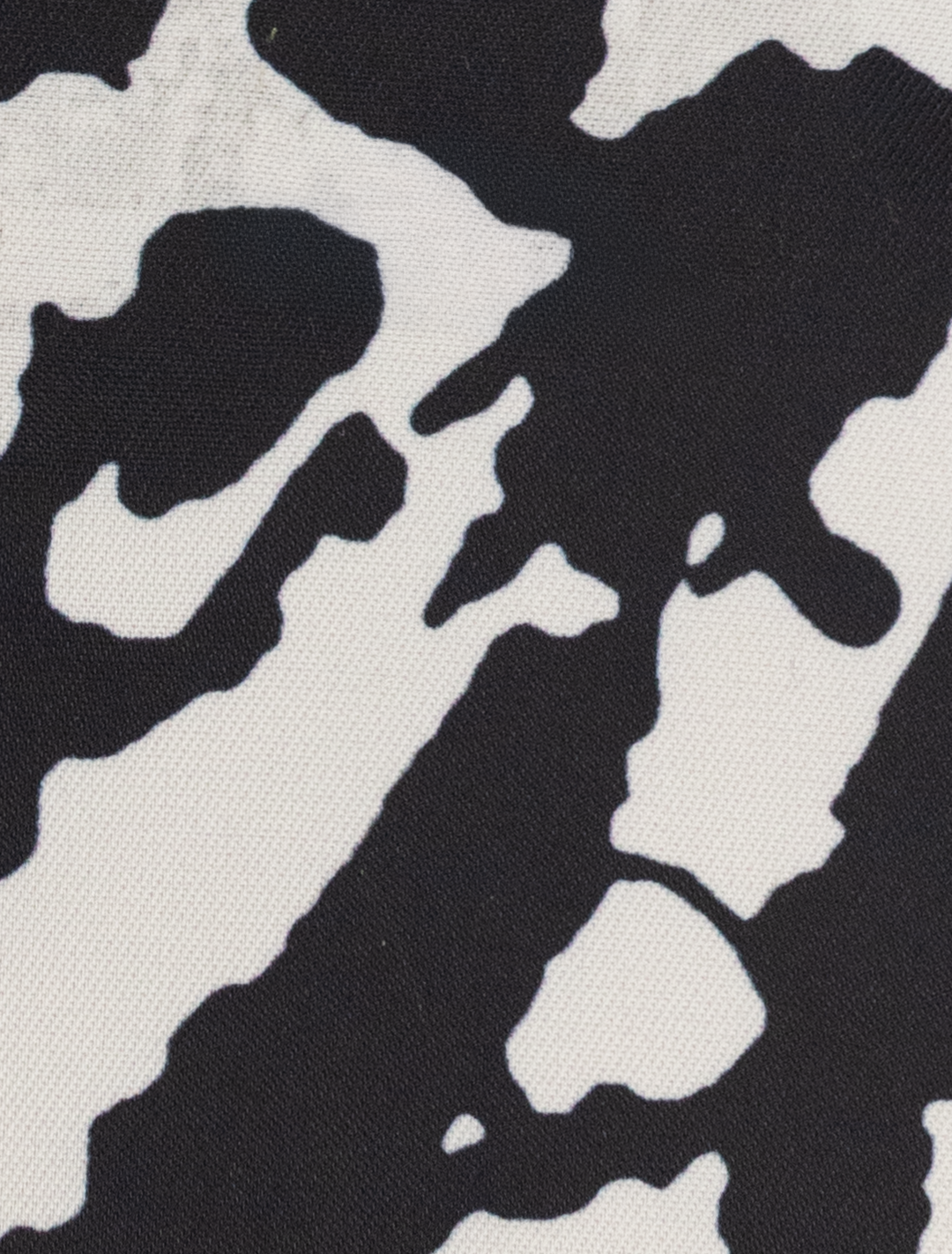 Detail of a FUBU Iron Grey Peak Lapel 2-Piece Suit by Fubu The Colle, featuring a black and white abstract pattern that mimics cow spots.