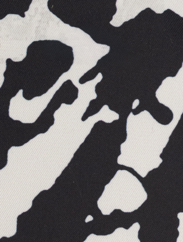 Detail of a FUBU Iron Grey Peak Lapel 2-Piece Suit by Fubu The Colle, featuring a black and white abstract pattern that mimics cow spots.