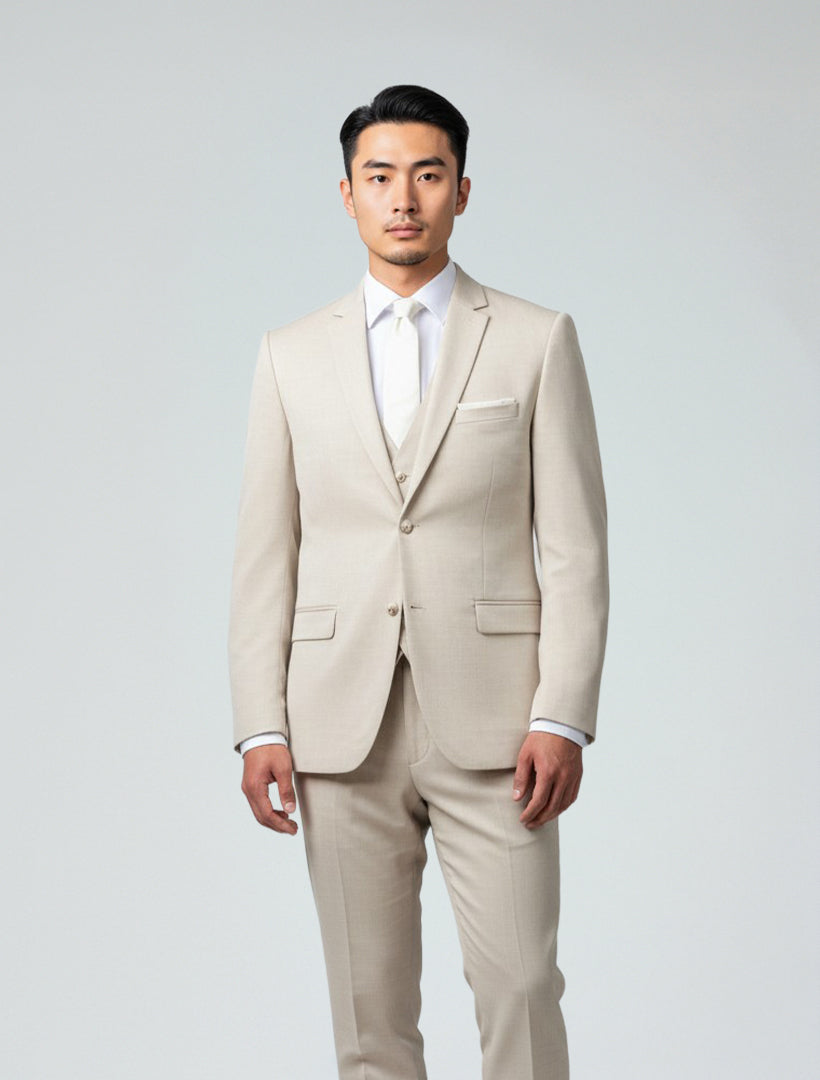 A man stands facing forward, wearing the Couture 1910 Men's Tan Suit Jacket with a white dress shirt and tie against a plain light background.