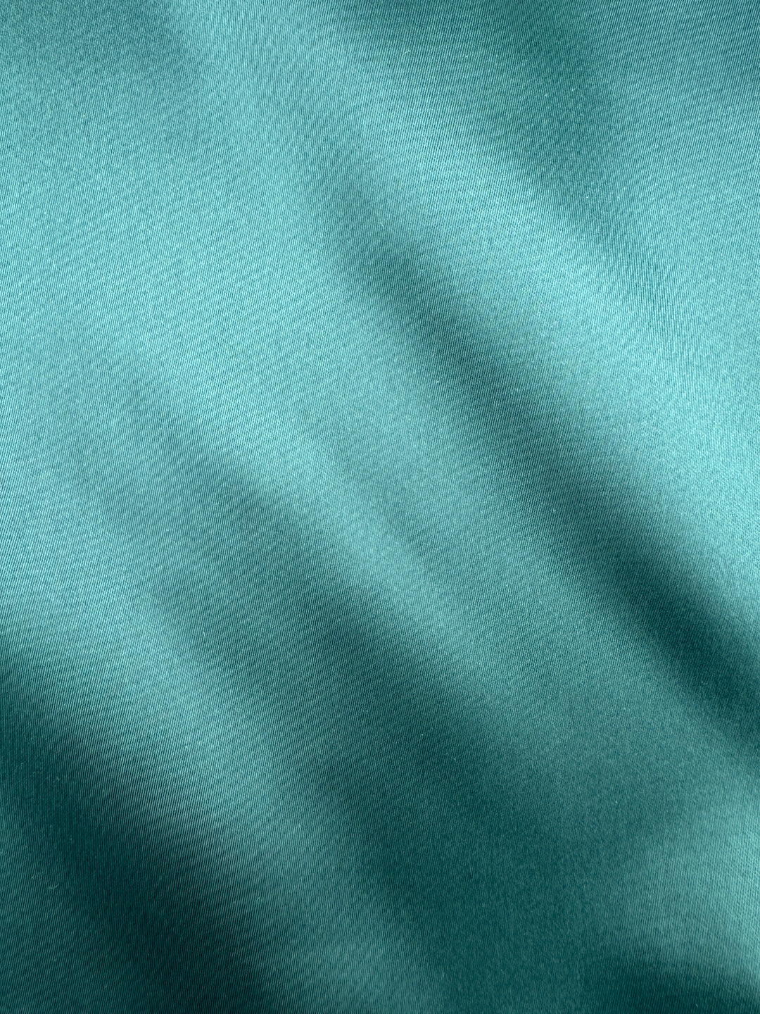 Close-up of the Karako Collecti Emerald Pocket Square Handkerchief, featuring a smooth teal microfiber fabric with gentle diagonal folds and a subtle sheen—an ideal formal accessory or men&