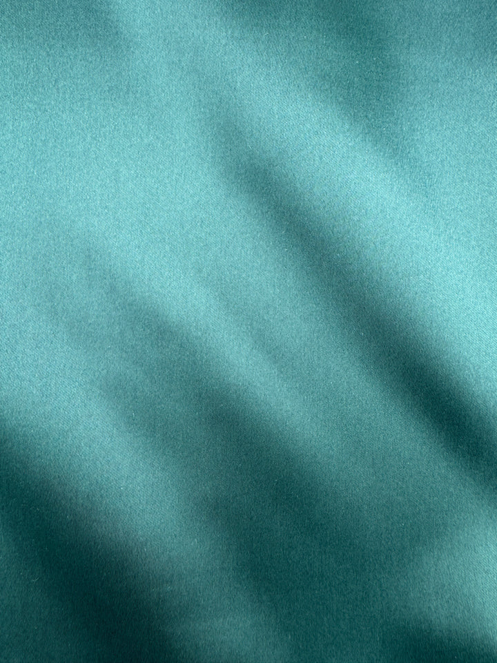 Close-up of the Karako Collecti Emerald Pocket Square Handkerchief, featuring a smooth teal microfiber fabric with gentle diagonal folds and a subtle sheen—an ideal formal accessory or men&