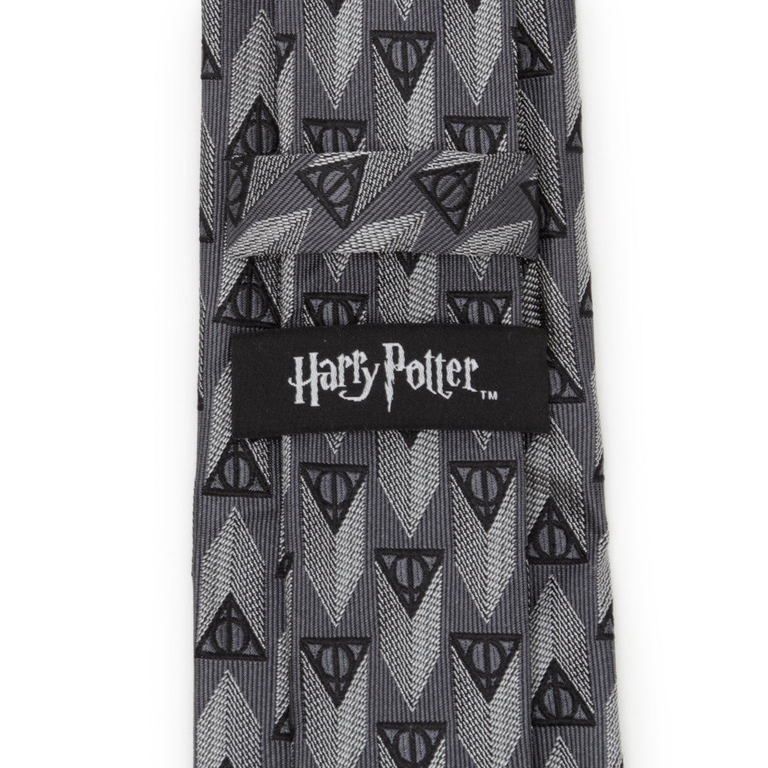 Gray Harry Potter Deathly Hallows Gray Silk Men’s Tie with a repeating Deathly Hallows symbol pattern and a Cufflinks.com brand label on the back.