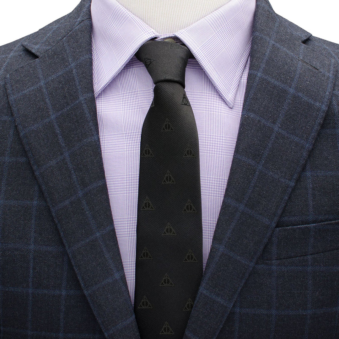 A black Harry Potter Deathly Hallows Tie worn with a light purple dress shirt and a navy blue plaid blazer.