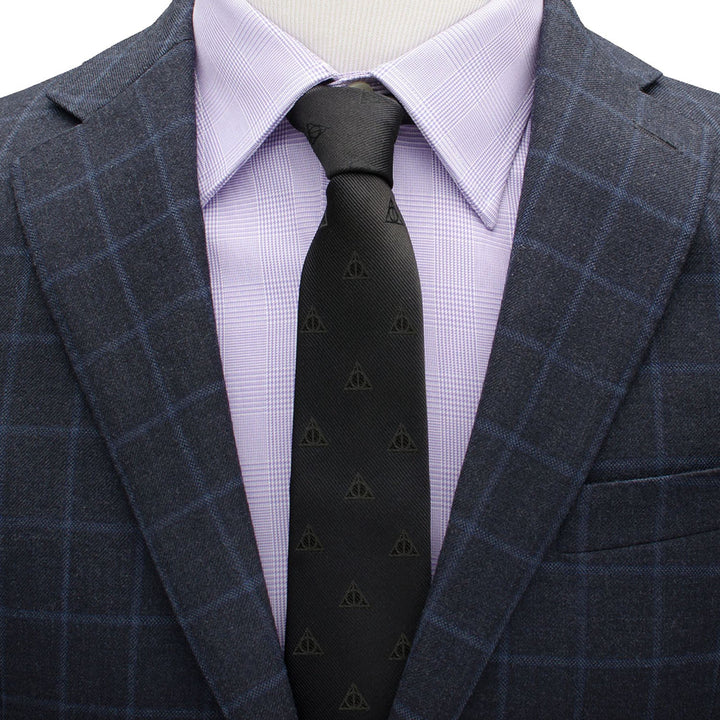 A black Harry Potter Deathly Hallows Tie worn with a light purple dress shirt and a navy blue plaid blazer.