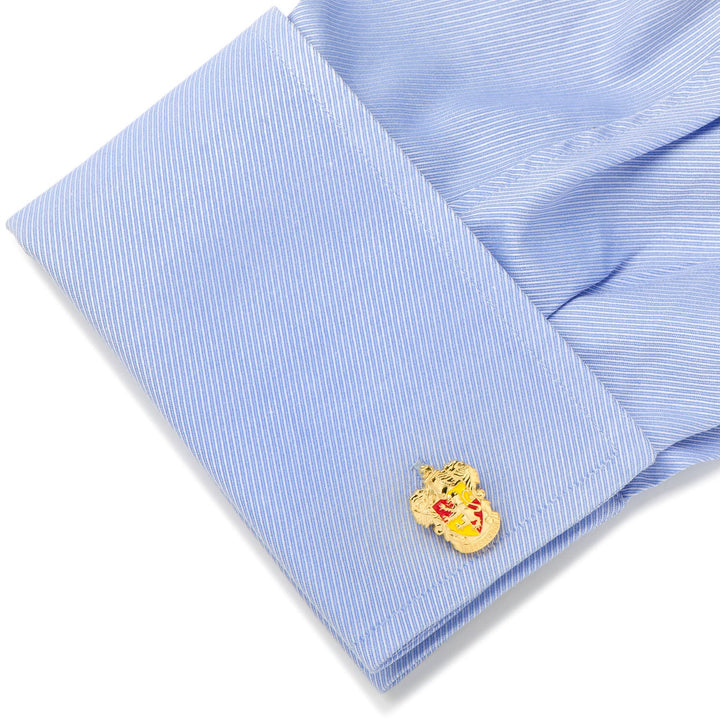 A gold-toned Harry Potter Gryffindor Crest Cufflinks lion crest attached to a light blue dress shirt sleeve.