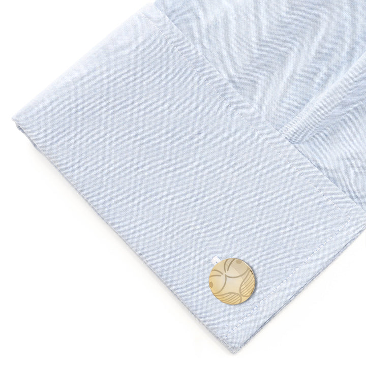 Harry Potter Golden Snitch Hidden Deathly Hallows Locket Cufflinks in a circular gold-toned design with an engraved winged sphere, shown on a light blue shirt cuff.