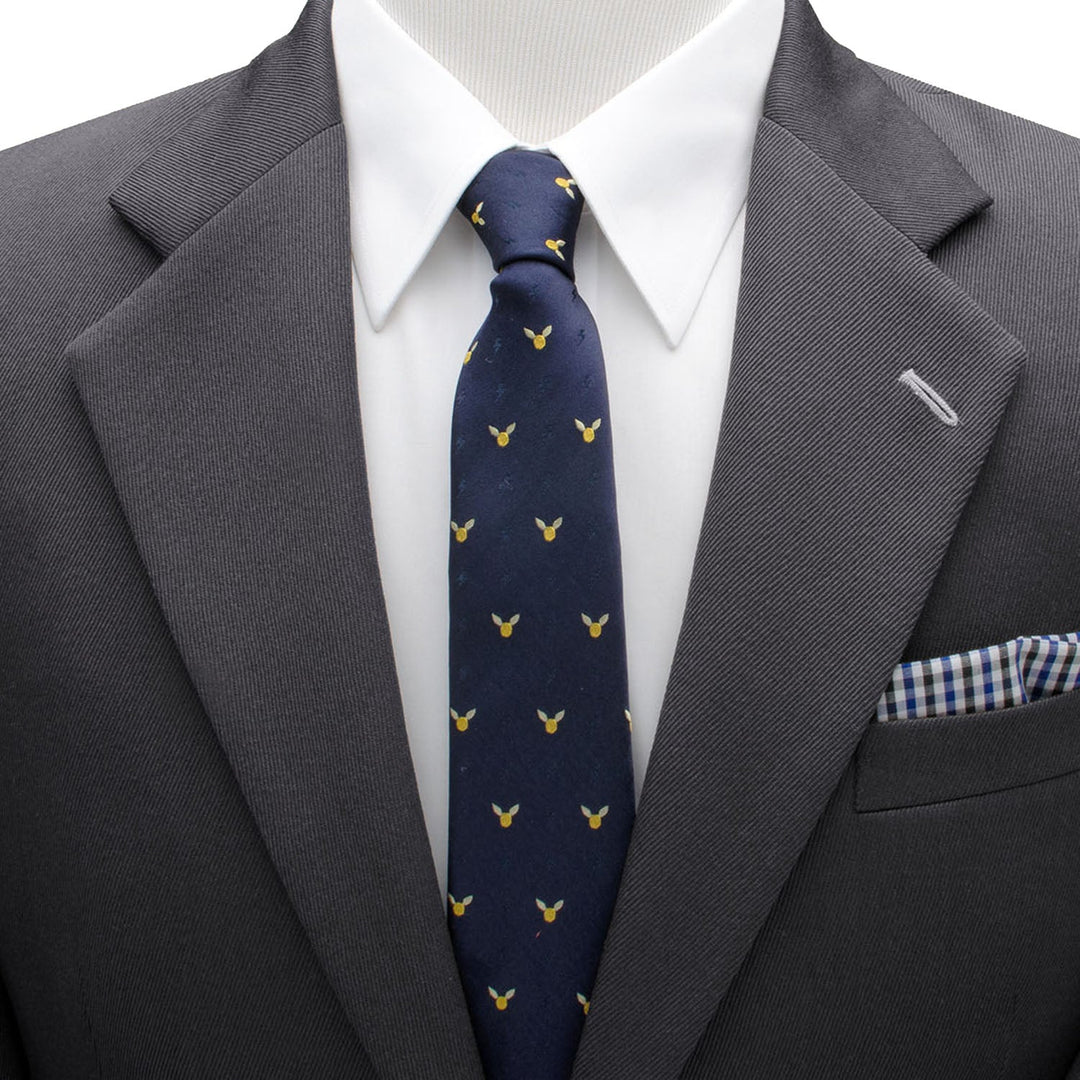 Harry Potter Golden Snitch Dot Tie in dark blue silk with small yellow winged spheres, worn with a charcoal suit, white shirt, and blue and white checkered pocket square.