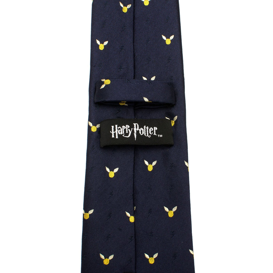 Dark blue Harry Potter Golden Snitch Dot Tie patterned with small gold and white winged snitch icons, featuring a black logo label on the back.