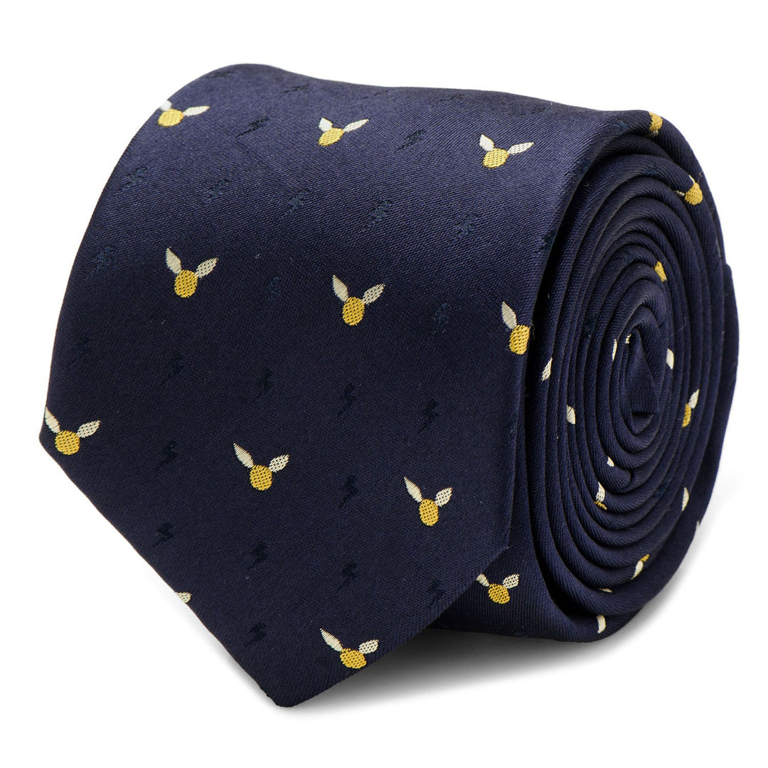 A rolled navy blue silk Harry Potter Golden Snitch Dot Tie by Cufflinks.com featuring a repeating pattern of small golden winged snitches and subtle lightning bolts.
