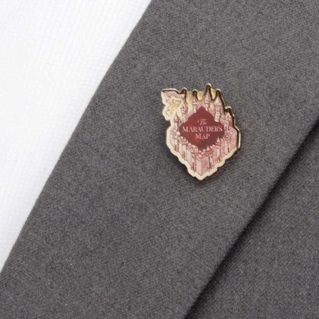 A red and gold Harry Potter Marauder’s Map lapel pin shaped like a castle, featuring the text “The Marauder’s Map” attached to a gray suit jacket.