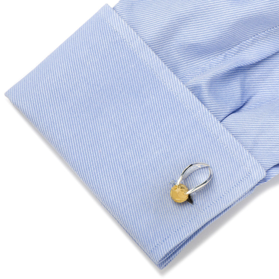 Harry Potter Golden Snitch 3D Cufflinks shaped like a winged gold ball attached to a light blue dress shirt cuff.
