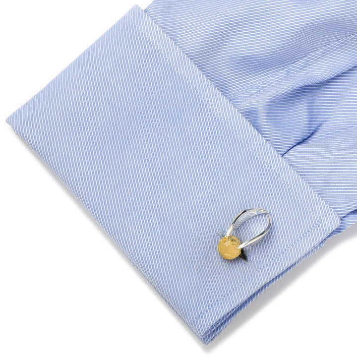 Harry Potter Golden Snitch 3D Cufflinks shaped like a winged gold ball attached to a light blue dress shirt cuff.